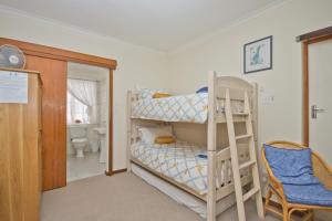 a room with two bunk beds and a bathroom at Plotsklaps Self Catering Cottage in Tokai