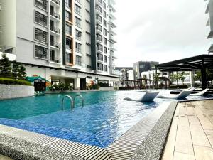 a swimming pool with two chairs in the middle of a building at KAVENUE Cybercity Sunset View, 8-10 pax in Donggongon
