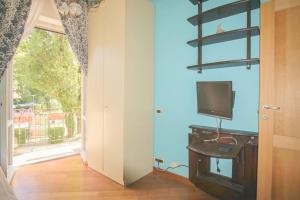 a room with a television on a table with a window at Windrose Casa Cortese in Pisa