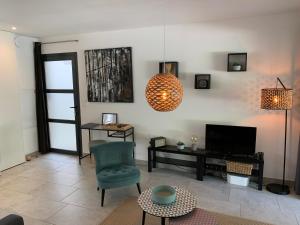 a living room with a chair and a television at Résidence "Les cyclistes", appartement "Akotee" in Malaucène