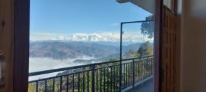 un balcón con vistas a una cordillera. en Debuli's Home Stay, en Almora