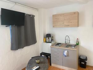 a small kitchen with a sink and a table at Monteurzimmer Knetzgau in Knetzgau