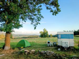 tenda e rimorchio in un campo di Caravane Vintage Atypique avec jacuzzi à la campagne a Sauvessanges