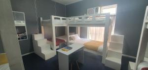 a small room with a bunk bed and a desk at CBD City views on 61 wale street by M&B in Cape Town