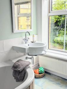 a bathroom with a sink and a toilet and a window at Victorian Town House - Sleeps 6 in Tywyn +30 photos
