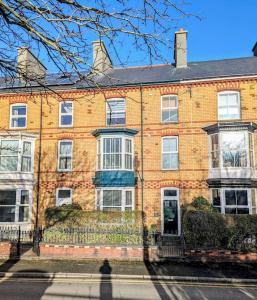 a large brick building with white windows on a street at Victorian Town House - Sleeps 6 in Tywyn