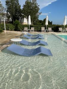 ポルト・チェザーレオにあるPodere40 Country Hotelの水中に青い椅子とテーブルが置かれたプール +123枚の写真