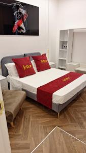 a bedroom with a king sized bed with red pillows at Kore Suite Napoli in Naples