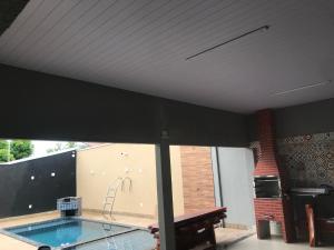 a swimming pool in a house with a large window at Céu azul in Araguaína +1 photo