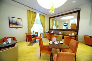 ein Restaurant mit Tischen und Stühlen und ein Esszimmer in der Unterkunft Monaco Hotel in Dubai