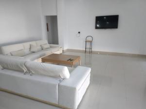 a white living room with a white couch and a table at Très belle villa avec piscine in Midoun