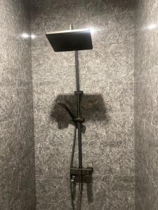 a light on a tripod in a room with a wall at ЖК Алма Сити in Raimbek