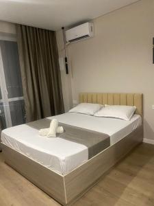 a bedroom with a bed with white sheets at ЖК Алма Сити in Raimbek