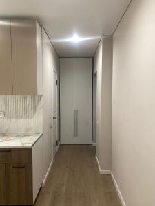 an empty kitchen with white cabinets and a hallway at ЖК Алма Сити in Raimbek