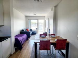 una sala de estar con una mesa y un sofá en Top floor, en Espoo