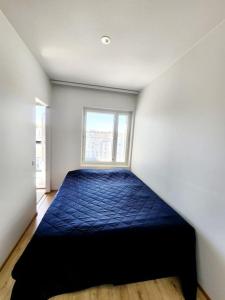 1 dormitorio con 1 cama azul en una habitación con ventana en Top floor, en Espoo 2 fotos más