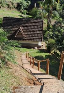 a garden with a wooden fence in the grass at Canto dos Ventos in Nova Friburgo +4 photos