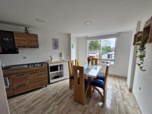 a kitchen with a table and chairs and a kitchen with a window at Villa Quintero 302 in Santa Rosa de Cabal