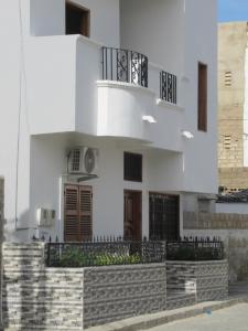 Edificio blanco con balcón en la parte superior en Résidence Séjour Téranga, en Saint-Louis