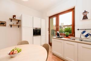 una cucina con un tavolo con una ciotola di frutta sopra di Design Retreat a Saluzzo - Comfort e Stile Unico a Saluzzo Altre 16 foto