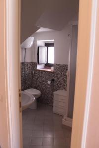 baño con aseo y ventana en Carruggiu Casavacanze, en Caltagirone