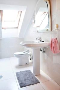 a white bathroom with a sink and a mirror at Apartamento en Somo con 2 plazas de garaje in Somo