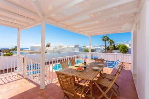 a patio with a wooden table and chairs on a balcony at Villa Adella in Tías