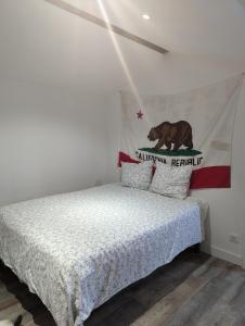 a bedroom with a bed with a flag on the wall at Chambre California in Ondres
