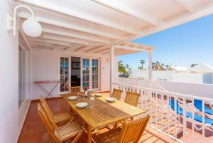 a dining room with a table and chairs on a balcony at Villa Adella in Tías