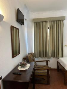 a room with a table and a chair and a bed at Copacabana Residencial in Costa da Caparica