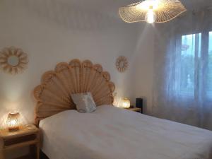 ein Schlafzimmer mit einem Bett mit einem hölzernen Kopfteil in der Unterkunft Villa de standing avec gd jardin arboré près d'Argelès sur Mer in Saint-André