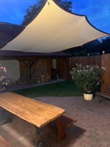 a wooden picnic table under a tent in a backyard at Domek na růžku celá chalupa in Vémyslice