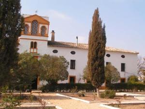 ein großes weißes Gebäude mit Bäumen davor in der Unterkunft Casa Rural Herrera in Villacarrillo