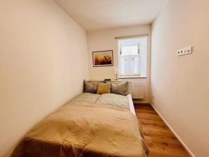 a bed in a small room with a window at FeelingHomeApartment in Dinkelsbühl