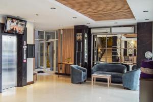 a living room with a couch and a tv at Hotel Dalu in Semarang