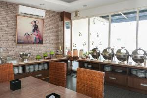 a dining room with a table and a brick wall at Hotel Dalu in Semarang
