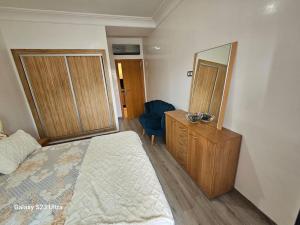 a bedroom with a bed and a dresser and a mirror at Studio a Mohammedia pied dans l'eau in Mohammedia +11 photos