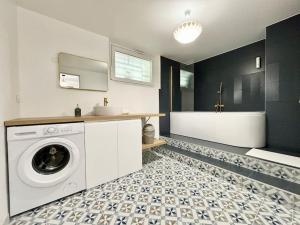 a bathroom with a washing machine and a tub at Appartement Indépendant, tout confort avec terrasse in Valence