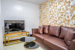 un salon avec un canapé marron et une table dans l'établissement Oka tagaytay escape, à Casile