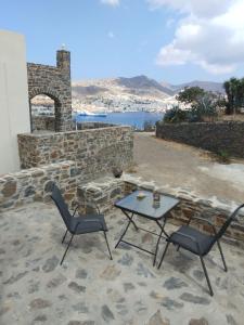 a table and chairs on a patio with a view at Aloe Apartments Syros in Lazaréta