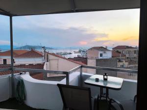 a balcony with a table and a view of a city at Aegina Downtown Apartments 2 in Aegina Town +15 photos