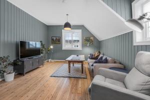 a living room with a couch and a tv at Sentral leilighet i klassisk hus! in Lillehammer