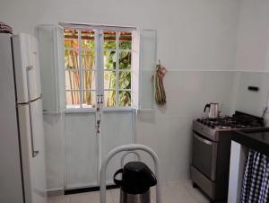 ジョアンペソアにあるCASA À 3 KM PRAIA TAMBAÚのキッチン(冷蔵庫付)、窓が備わります。