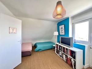 a small room with a bed and a television at Maison familiale La Fontaine tout confort à 400m de la plage in Plobannalec-Lesconil