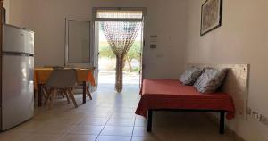 a living room with a couch and a table and a refrigerator at Odegos Residence Torre dell'Orso in Torre dell'Orso