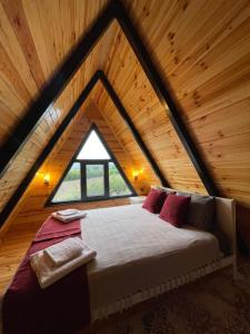 a bed in the middle of a room in a attic at Müngen Bungalovs in Kemer
