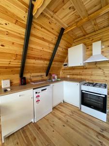 a kitchen with white cabinets and a wooden ceiling at Müngen Bungalovs in Kemer
