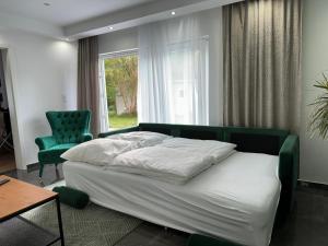 a bedroom with a bed and a chair and a window at Ferienhaus Bremen Wunder-Grill-Relax Garten in Aumund