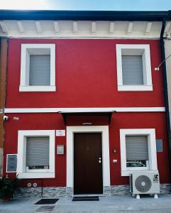 a red building with a door and two windows at La Casa Rossa in Ca' di David