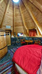 a bedroom with a red bed in a attic at KOZAK Apartments & Restaurant in Mojkovac